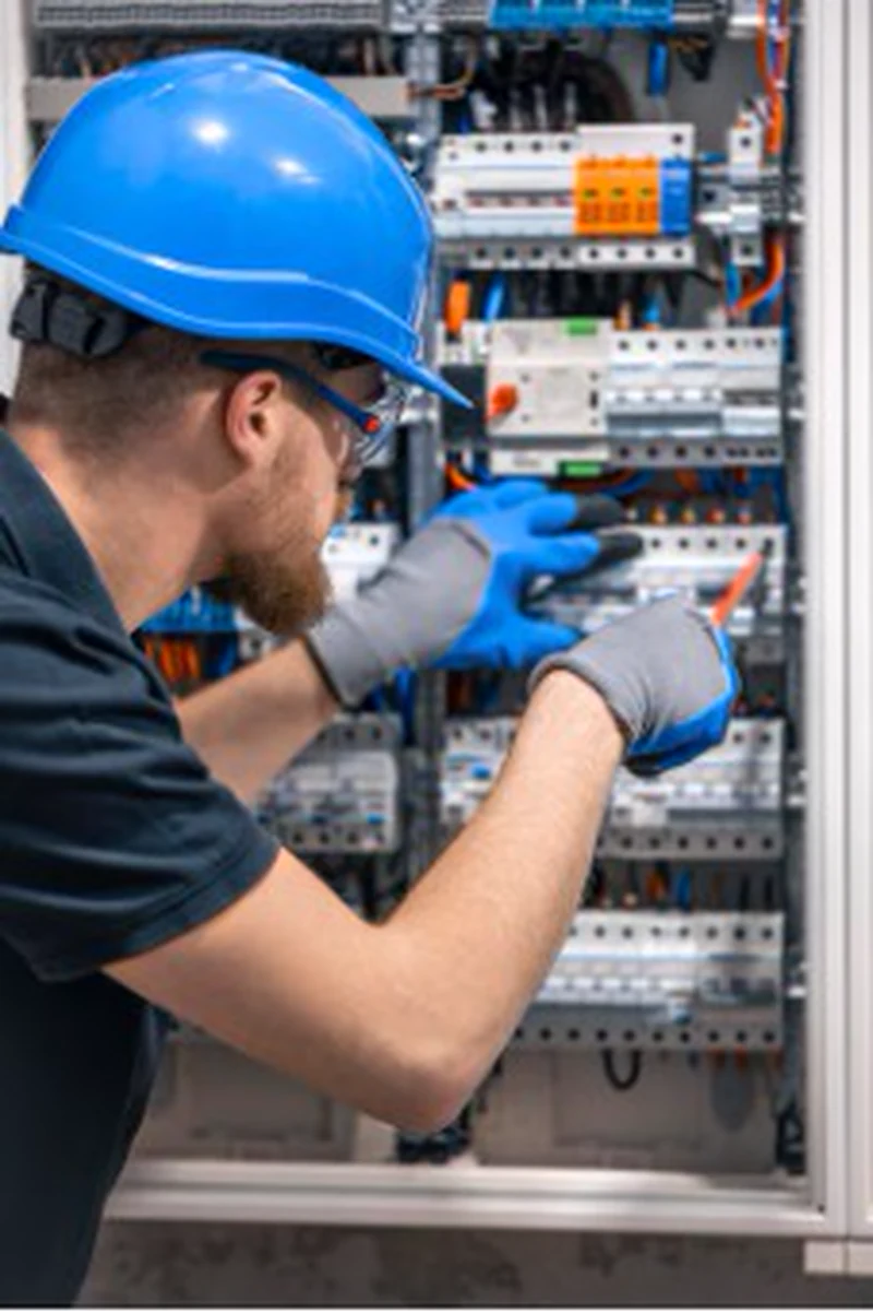 Electrical-panel wiring for PTC Loma Campana by a technician wearing a blue hard hat
